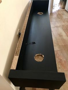 a black table with holes in it on the floor next to a door and window