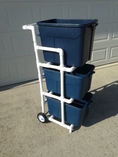 three blue plastic containers stacked on top of each other in front of a garage door