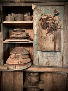 an old wooden cabinet filled with pots and pans next to a bag on top of a shelf