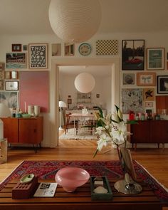 a living room filled with furniture and pictures on the wall next to a coffee table