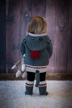 an image of a little boy dressed up in a sweater and leggings with a teddy bear