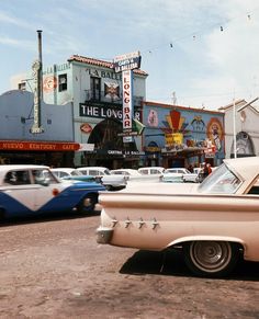 an old car parked in front of a building with signs on it's side