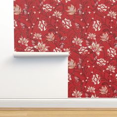 a red wallpaper with white flowers on it and a wooden floor in the background