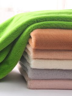 a stack of towels folded on top of each other in different colors and sizes,