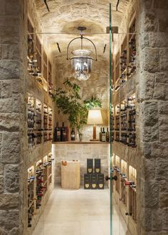 an image of a wine cellar with many bottles on the shelves and chandelier hanging from the ceiling