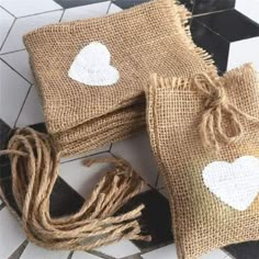 two burlap bags with white hearts on them sitting on a black and white checkered floor