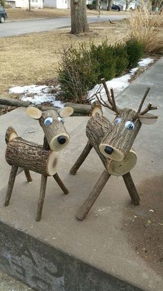 two wooden deer sculptures sitting on top of a sidewalk