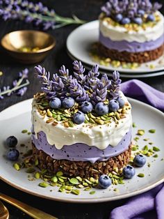 two cakes with lavender frosting and sprinkles on plates next to each other