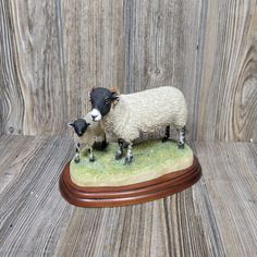 a sheep and lamb figurine sitting on top of a wooden table