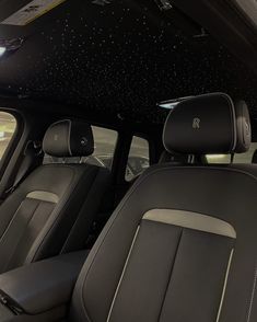 the interior of a car with black leather and white stitching on the floor,