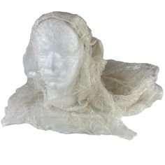 a white mannequin's head covered in plastic wrap on a white background