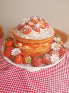 a stack of pancakes covered in powdered sugar with strawberries and daisies on top