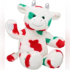 a white and red cow stuffed animal with horns on it's head sitting down