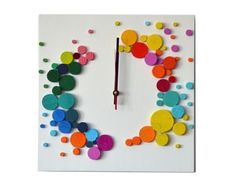 a clock made out of colored circles on a white surface with a red second hand