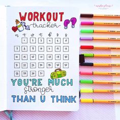 a notebook with an exercise tracker and colored pencils next to it