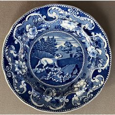 a blue and white plate with an animal scene on it