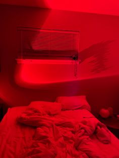 a red light illuminates a bed in a room with an air conditioner