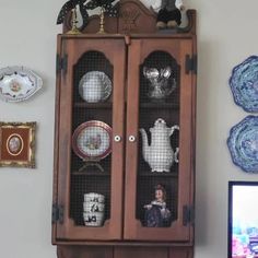 an old china cabinet with glass doors and plates on it