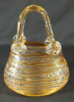 a yellow glass purse sitting on top of a table