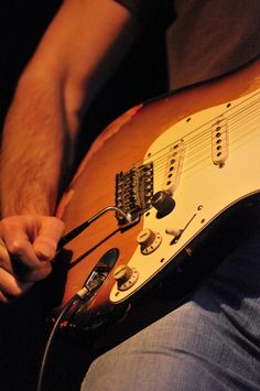 a person holding an electric guitar in their hands