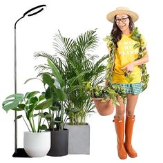 a woman in yellow shirt and shorts standing next to potted plants on white background