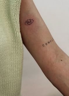 a woman's arm with a tattoo that reads compui and an eye