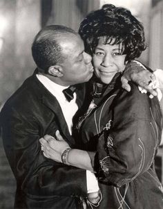 an old black and white photo of a man kissing a woman