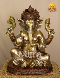 an elephant statue sitting on top of a wooden table next to a white wall and gold trimming