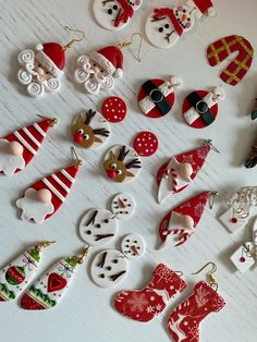 many different types of christmas decorations on a white table with snowflakes and santa hats