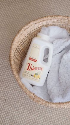 a bottle of cleaner sitting in a basket next to a white towel on the floor