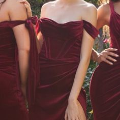 three women in long red dresses standing next to each other with their hands on their hips