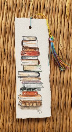 a stack of books on top of each other next to a tasseled bookmark