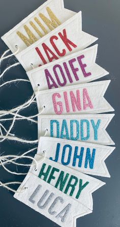 four handmade name tags hanging from string