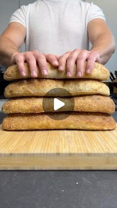 a man is making bread on top of a cutting board with the video below him