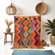 a large multicolored rug in the corner of a room with potted plants