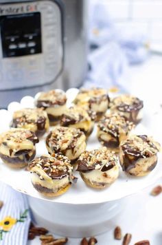 chocolate covered bananas on a white plate next to an instant pressure cooker with pecans in the background