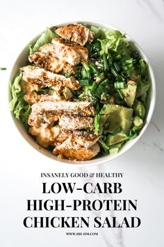 a bowl filled with chicken and lettuce on top of a white countertop