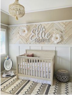 a baby's room with a white crib and wooden herringbone accent wall