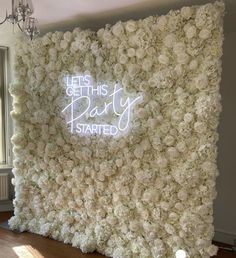 a white flower wall with the words let's get this party started