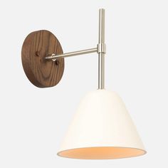 a wall light with a white shade hanging from it's arm and wooden base