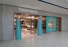 the entrance to tiffany & co store in an upscale shopping mall with blue and white columns