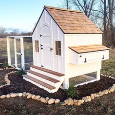 a white chicken coop with steps leading up to it