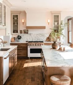 a kitchen with wooden floors and marble counter tops, along with an oven in the center