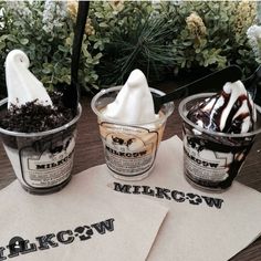 three ice cream sundaes sitting on top of a table