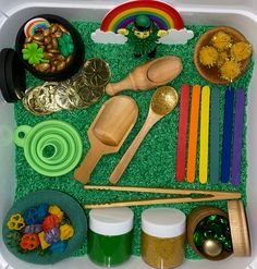 a plastic container filled with lots of different types of food and decorations on top of green grass