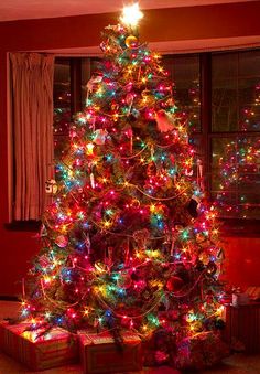 a brightly lit christmas tree with presents under it