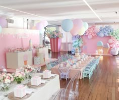 a room filled with lots of tables covered in balloons and cake on top of them