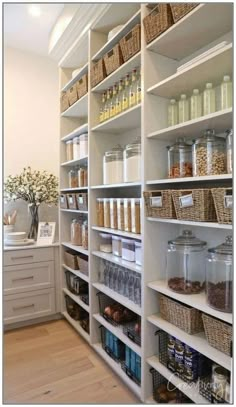 an organized pantry with white shelving and wicker baskets on the bottom shelfs