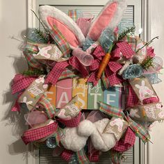 a wreath with bunny ears, carrots and letters on it that say happy easter