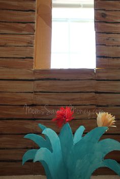 a vase filled with flowers sitting in front of a wooden wall and window sill